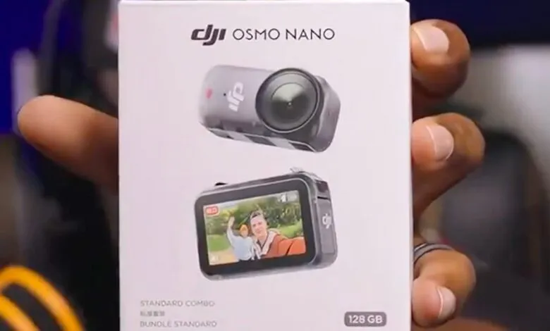 Hand holding DJI Osmo Nano 128GB Standard Combo box. The box shows the camera in two views.