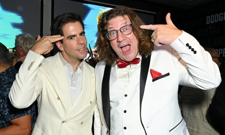 Magicians David Blaine and Penn Jillette playfully pose with fingers to their heads.