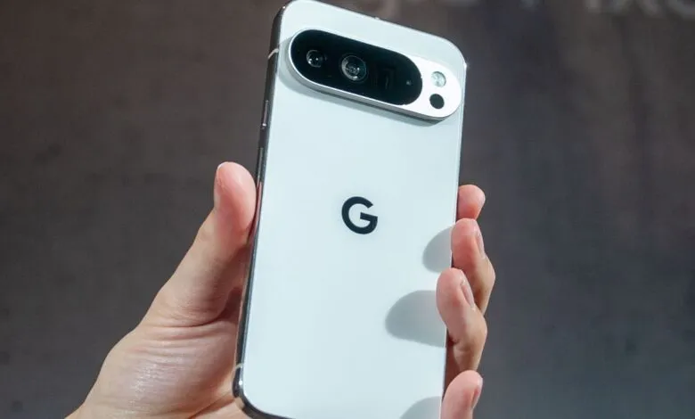 A hand holds a white Google Pixel phone, showcasing its camera system and Google logo.