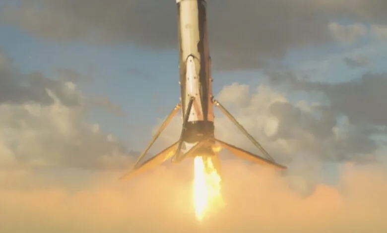 Rocket launch viewed from below, fiery engine ignition against cloudy sky.