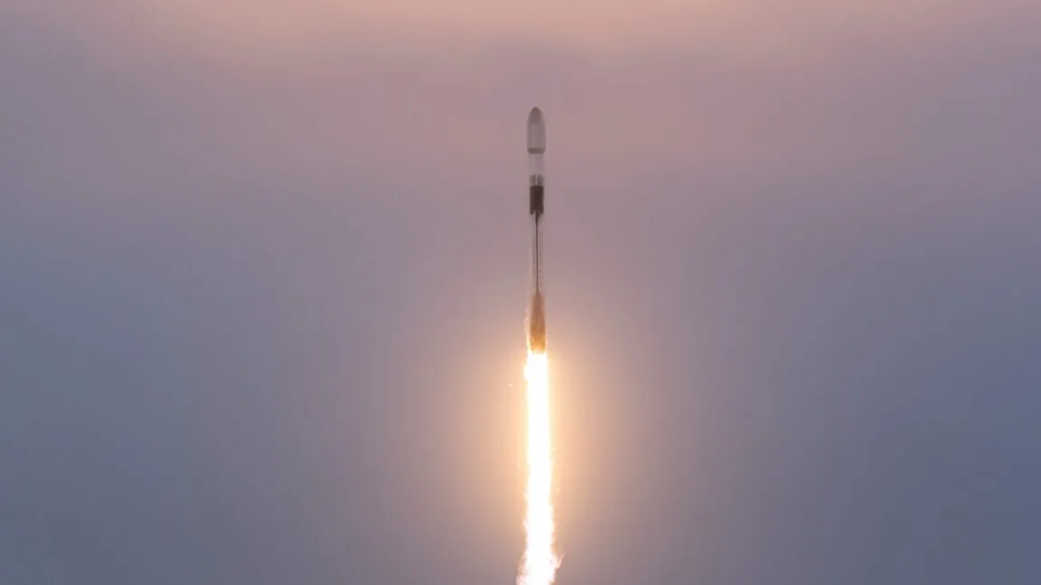 Rocket launching into a dusky sky, bright flames illuminating the bottom.