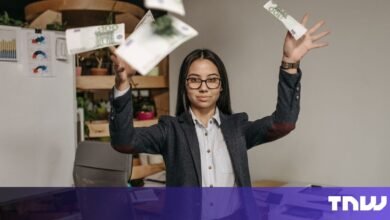 Businesswoman joyfully throws Euro banknotes in the air, celebrating success in a modern office.