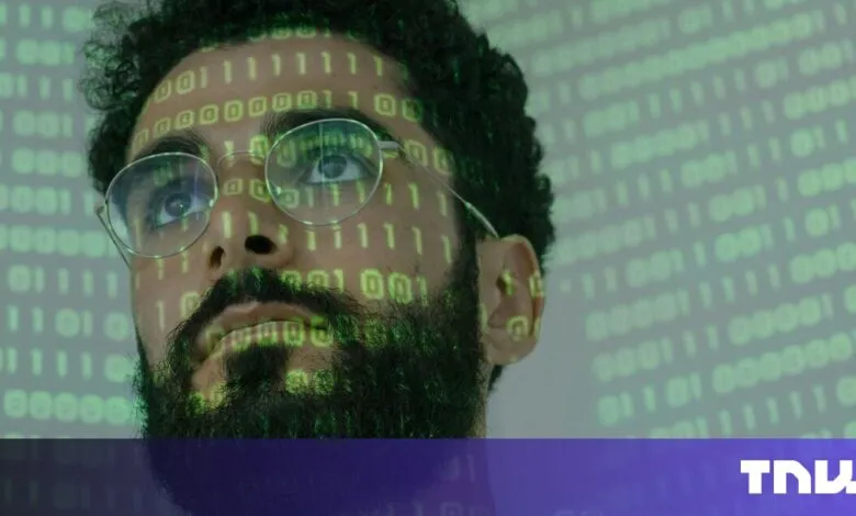 Close-up of a man's face overlaid with green binary code, looking thoughtfully upward.