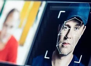 Close-up of a man's face with a digital facial recognition grid overlaid.