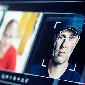 Close-up of a man's face with a digital facial recognition grid overlaid.