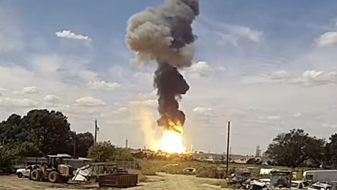 Massive explosion with thick black smoke billowing into a cloudy sky.
