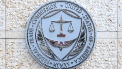 Close-up of the Federal Trade Commission (FTC) seal, a metallic emblem on a stone wall.