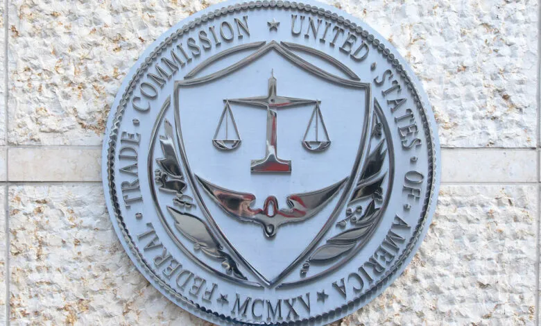 Close-up of the Federal Trade Commission (FTC) seal, a metallic emblem on a stone wall.