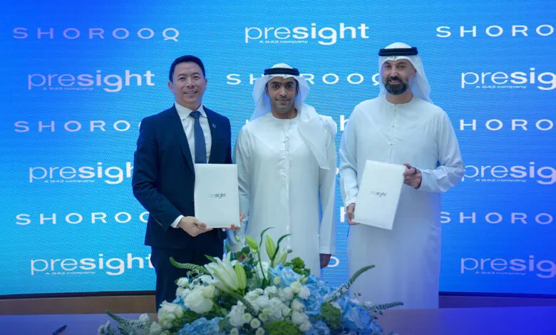 Three men in business attire stand holding documents at a Presight and Shorooq event.