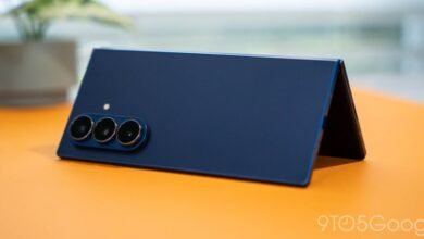 Close-up of a dark blue foldable smartphone with a triple camera system.