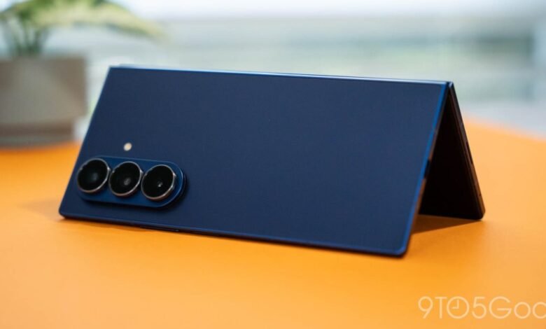 Close-up of a dark blue foldable smartphone with a triple camera system.