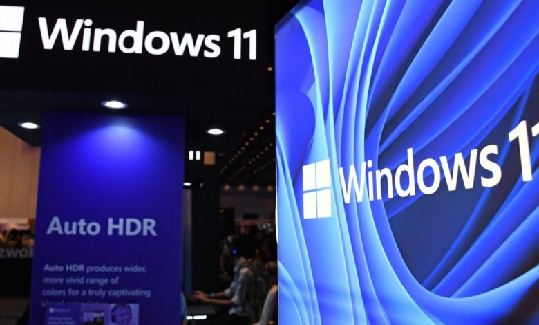 Windows 11 logo and branding displayed on screens at a tech event.