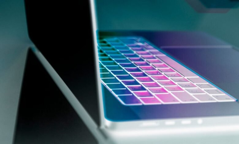 Close-up of a laptop keyboard with a vibrant purple and teal gradient.