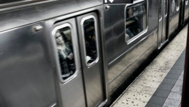 Woman's face reflected in the window of a moving subway train.