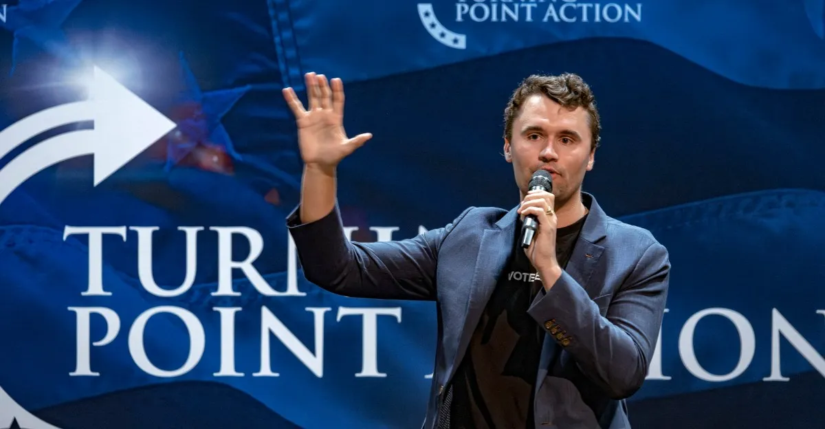 Charlie Kirk, Turning Point USA founder, speaks at an event, gesturing with his hand.
