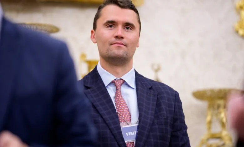 Portrait of a man in a suit and tie, wearing a visitor's badge.