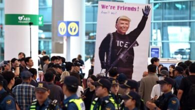 Large poster of Donald Trump in ICE uniform at airport, surrounded by onlookers.