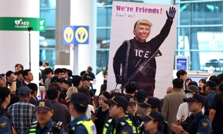 Large poster of Donald Trump in ICE uniform at airport, surrounded by onlookers.