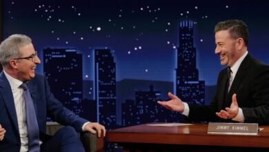 Stephen Colbert and Jimmy Kimmel laughing together on a talk show set.