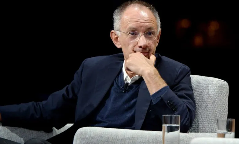 Marc Benioff, Salesforce CEO, sits thoughtfully in a chair during a conference.
