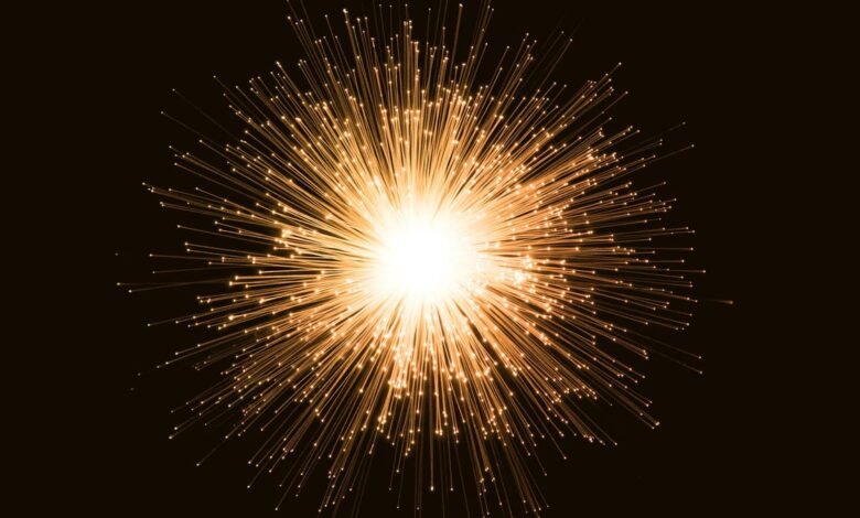 Abstract burst of glowing orange fiber optic strands against a dark background.