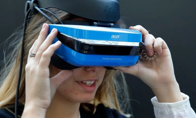 Woman wearing Acer Windows Mixed Reality headset, a vibrant blue device with visible cameras.