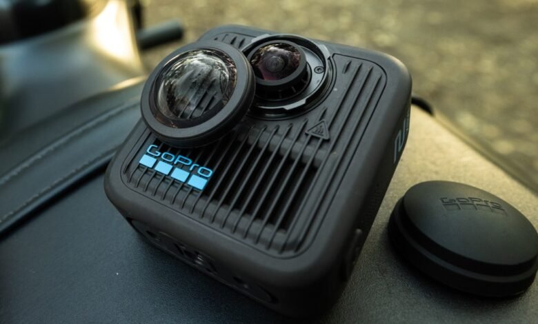GoPro Max 2 360° camera with lens cap and mount, resting on a black surface.