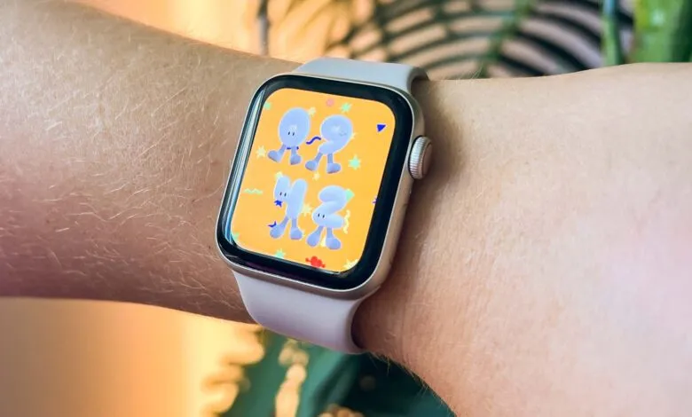 Apple Watch with a playful, yellow watch face featuring cartoon numbers and shapes.