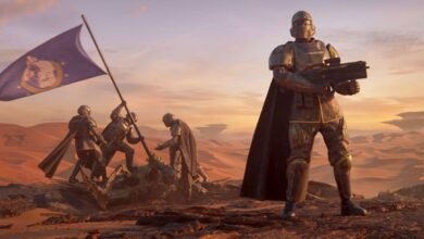 A soldier in futuristic armor stands guard while others plant a flag on a desert planet.