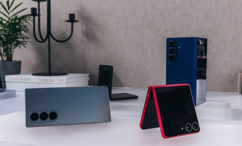 Three modern foldable smartphones displayed on a white surface with decorative elements.