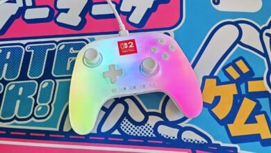 White Nintendo Switch controller with rainbow backlight on a colorful surface.