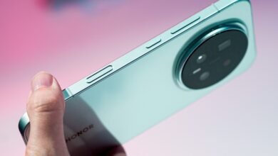 Close-up of a mint green Honor Magic 8 Pro smartphone, showcasing its unique circular camera design and side buttons.