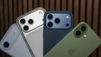 Close-up of iPhone models in various cases: silver, dark blue, and olive green, showcasing their camera systems.