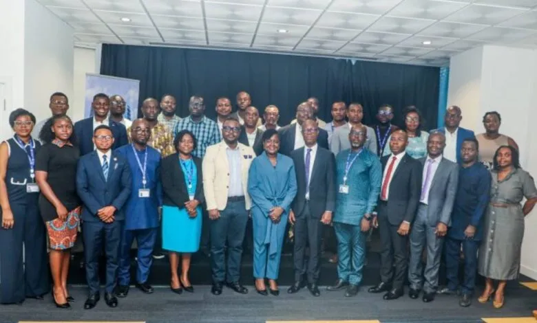 Diverse group of professionals in business attire posing for a group photo at an event.