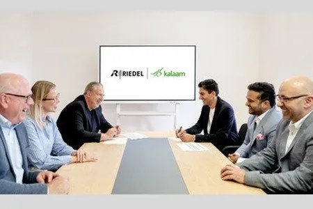 Riedel and Kalaam representatives smiling at a meeting, signing a partnership agreement.