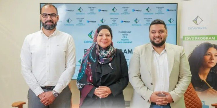 Three professionals stand before a banner promoting the Challenge Fund for Youth Employment and the EDVS program.