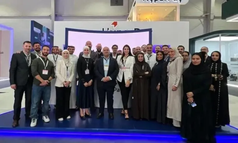 Diverse HyperPay team posing for a group photo at a conference booth.