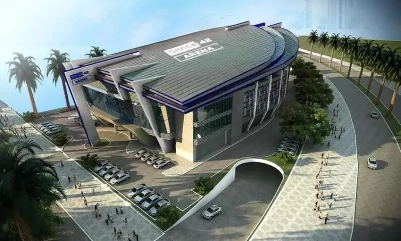 Architectural rendering of Space 42 Arena, a modern building with a curved roof and palm trees nearby.