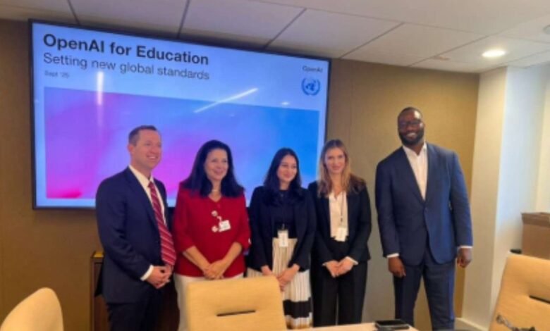 Five professionals stand in front of a screen displaying 'OpenAI for Education'.
