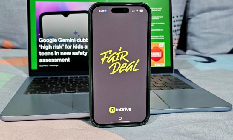 Smartphone displaying the inDrive Fair Deal app on a laptop with a TechCrunch article visible.