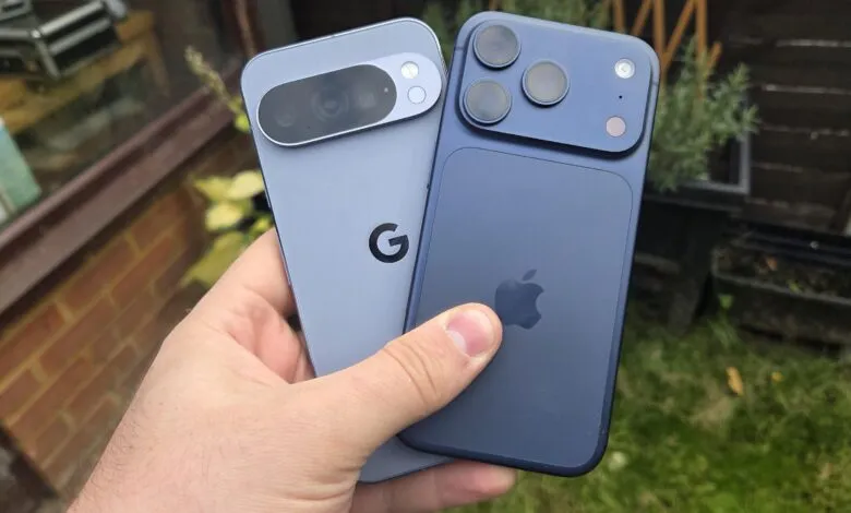 Close-up of a hand holding a Google Pixel phone next to an iPhone.