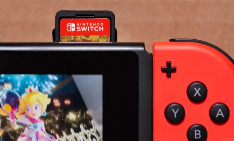 Close-up of a Nintendo Switch game card inserted into a red and black Nintendo Switch console.