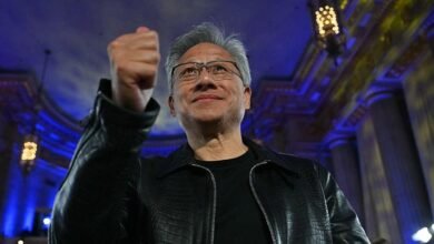 Jensen Huang, CEO of Nvidia, smiles and raises his fist in a celebratory gesture.