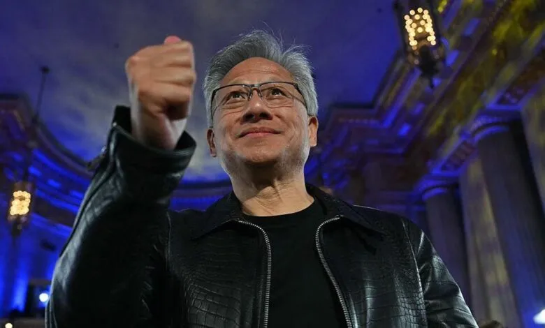 Jensen Huang, CEO of Nvidia, smiles and raises his fist in a celebratory gesture.