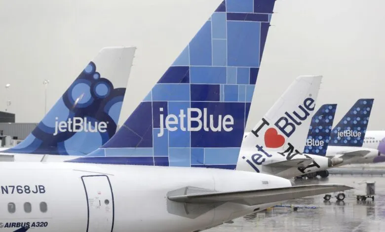Close-up of several JetBlue airplane tails, each with a unique design featuring the JetBlue logo and various blue patterns.