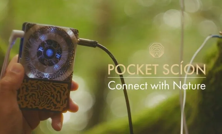 Person holding Pocket Scion device, connecting to nature. Intricate design, natural background.