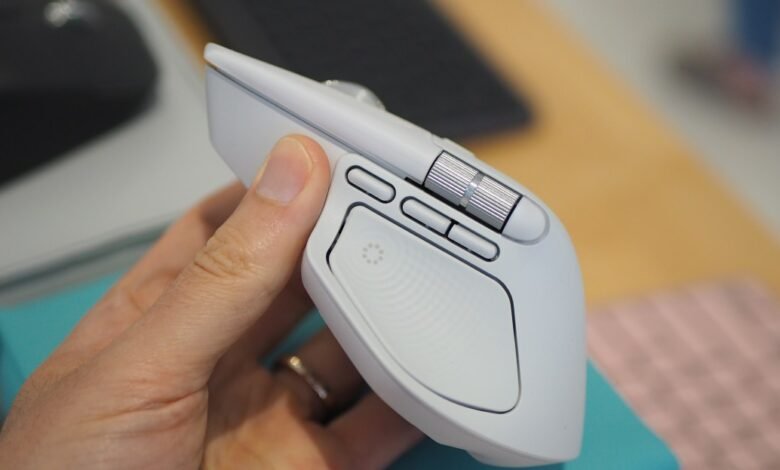 Close-up of a white Logitech MX Master 3S mouse held in a hand.
