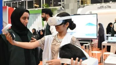 Children and adults experience virtual reality headsets at a tech expo in Oman.