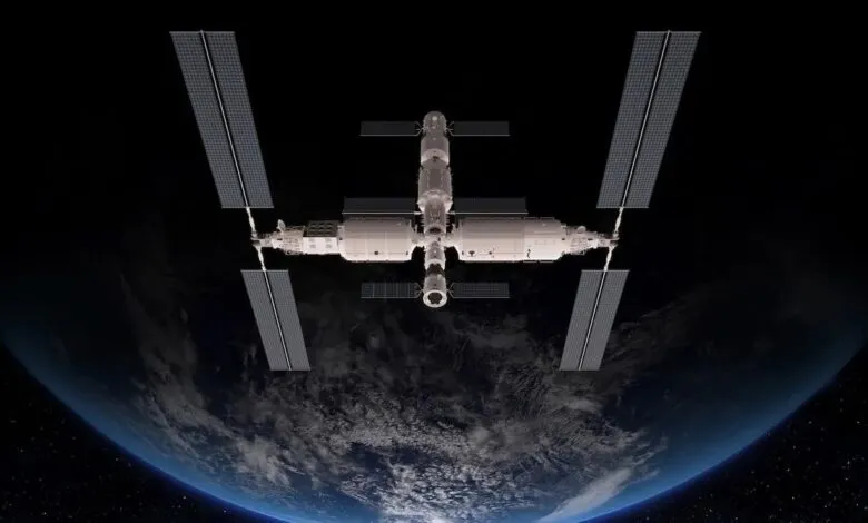 Space station orbiting Earth, showcasing solar panels and modules against a dark backdrop.