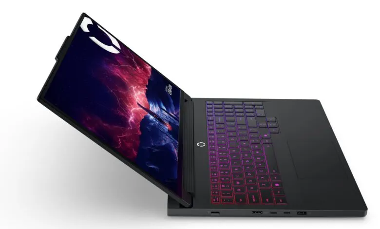 Sleek black gaming laptop with vibrant purple and pink keyboard backlighting, partially open, displaying a futuristic cityscape wallpaper.